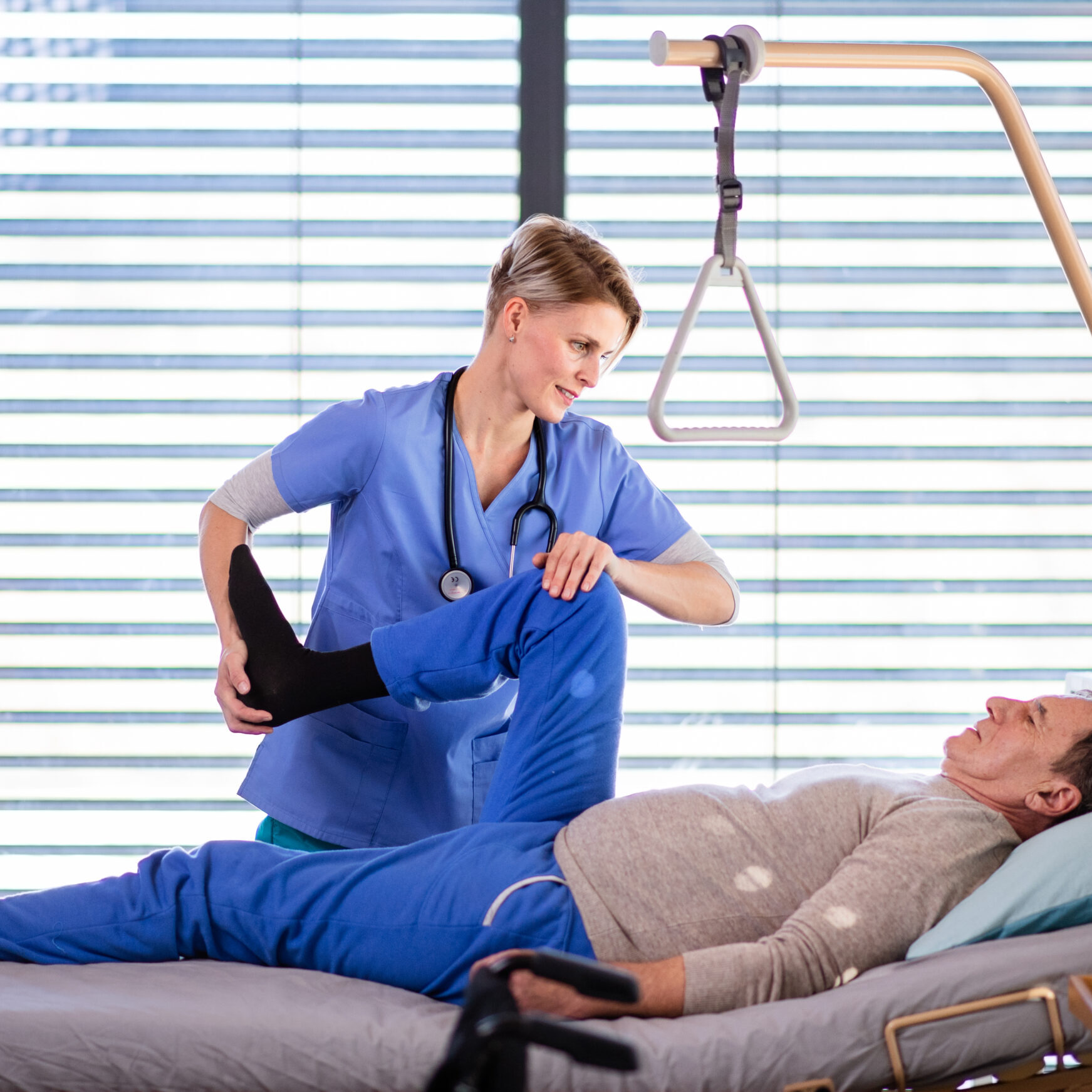 A healthcare worker and senior patient in hospital, physiotherapy concept.